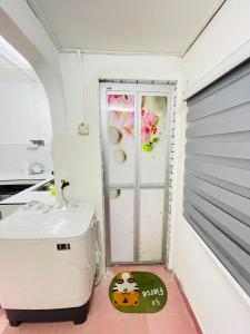 a small bathroom with a sink and a door at Home in Sepang, Homestay Mokhzan in Sepang