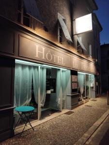 a store front of a hotel at night at Hôtel Les Thermes in Jonzac