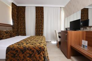 a hotel room with a bed and a desk at The Corner Park Hotel in Antalya
