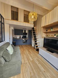 un grand salon avec un canapé et une cuisine dans l'établissement Frontignan petite maison coquette 30 m2 à 100 m de la plage, à Frontignan