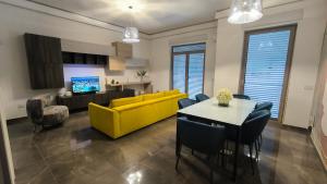 a living room with a yellow couch and a table at DimoraNOIDUE in Locorotondo