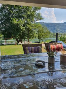 a table with chairs and a view of a field at Vikendica Marija, Culine in Mali Zvornik