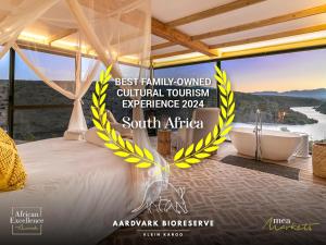 a poster for a resort with a bed and a bath tub at Aardvark Bioreserve in Ladismith