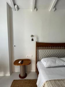 a bedroom with a bed and a wooden table at Evia Escape - Beachfront villa in Skála