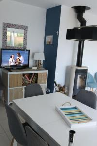a living room with a table and a tv at La maison de Qui miac in Quimiac