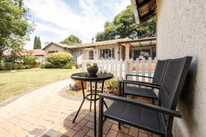 un patio con dos sillas y una mesa en Cottage on Keurboom, en Midrand