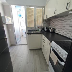 eine kleine Küche mit Spüle und Herd in der Unterkunft Apartamento luminoso y acogedor con vista al mar in Cullera