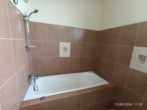 a bath tub in a tiled bathroom at MF Holiday Bungalow in Bandarawela +28 photos