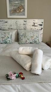 a bed with white blankets and pillows on it at Plett57 - Self Catering - Room No2 in Plettenberg Bay +5 photos