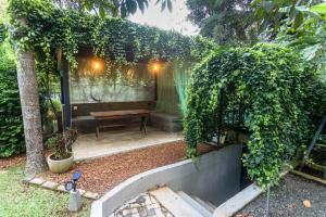 a garden with a bench and a table at 18 Villa in Hikkaduwa +39 photos