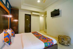 a bedroom with a bed and a flat screen tv at Via Manas Residency in Mumbai