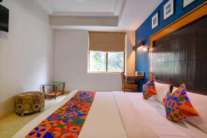 a bedroom with a bed with a colorful blanket on it at Via Manas Residency in Mumbai