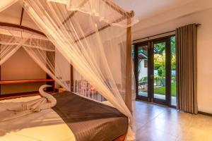 a bedroom with a bed with a canopy at 18 Villa in Hikkaduwa