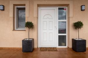 a white door with two potted plants next to it at Villa Cruceiro in Los Belones