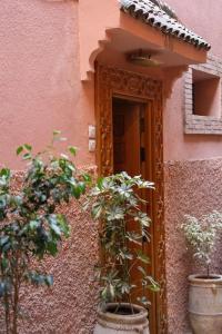 un ingresso a un edificio rosa con piante in vaso di Authentic house in the old Medina of Marrakech a Marrakech