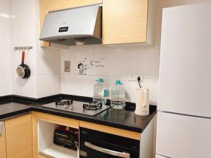 a kitchen with a stove and a white refrigerator at YoYo Youth Apartment in Guangzhou