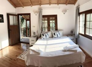 a large bedroom with a large bed with white sheets at Villa Plum Garden in Fethiye +48 photos