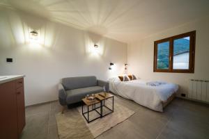 a bedroom with a bed and a couch and a window at Studio Conflans by ExplorHome - Albertville in Albertville