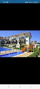 un gran edificio de apartamentos con piscina y parque infantil en Charming 3-Bedroom Home with Private Pool for Rent, en Fethiye