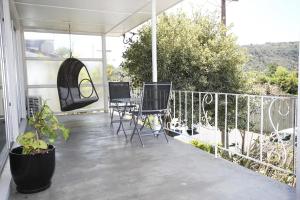 a patio with chairs and a table on a balcony at Waiwera Beach StopOver in Waiwera