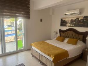 Un dormitorio con una cama grande y un balcón. en Charming 3-Bedroom Home with Private Pool for Rent, en Fethiye