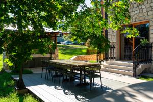 une table et des chaises assises sur une terrasse dans l'établissement Vila Gospavino Guvno, à Žabljak