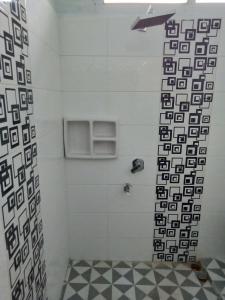 a bathroom with a shower with black and white tiles at Ratu Balqis Homestay in Banda Aceh