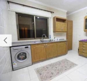 a kitchen with a sink and a washing machine at Apartment in Amman