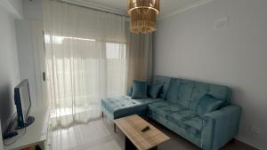 ein Wohnzimmer mit einem blauen Sofa und einem Tisch in der Unterkunft Elite North coast Seaview resort in El-Alamein