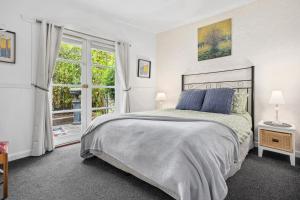 ein Schlafzimmer mit großem Bett und Fenster in der Unterkunft Croft Cottage in Hepburn Springs