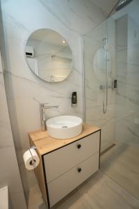 a bathroom with a sink and a shower with a mirror at Villa Malo More in Trogir