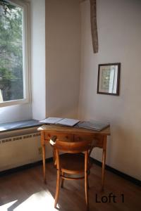 un bureau en bois avec une chaise à côté d'une fenêtre dans l'établissement Loft in San Lorenzo, à Gênes