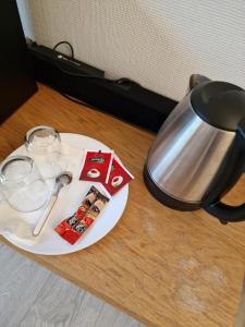 a plate with a tea pot and glasses on a table at Private room in to roomsapartment (Grunneløkka) in Oslo