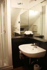 La salle de bains est pourvue d'un lavabo et d'un miroir. dans l'établissement Loft in San Lorenzo, à Gênes