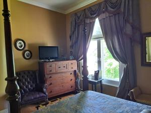 a bedroom with a bed and a dresser and a window at Gîte au Charme Victorien in Beauceville