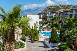 widok na ośrodek z palmami i basenem w obiekcie Grand Hotel Holiday Resort w mieście Hersonissos