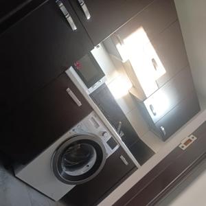a bathroom with a washing machine in a room at Nord Accomodation in Bucharest