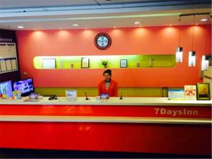 a woman standing at a counter in a store at 7Days Inn Harbin Chengde Plaza in Harbin