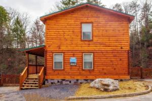 ピジョン・フォージにあるPapa Wolf's Cabin - POOL Communityのポーチと階段が備わる広いログキャビン