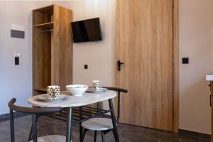 a room with a table and two chairs and a tv at Hotel12 in Leptokarya