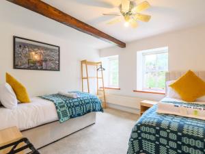 利兹Poplar Farm House - Book Your Spring Summer Events Pass The Keys的带两张床和吊扇的卧室