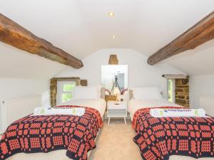 利兹Poplar Farm House - Book Your Spring Summer Events Pass The Keys的配有白色墙壁和木梁的客房内的两张床