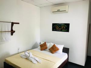 una habitación con una cama con un animal de peluche. en The Velvet Dambulla, en Dambulla 20 fotos más