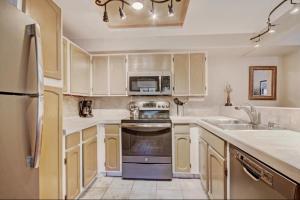 a kitchen with white cabinets and a stove top oven at 2 Bedroom Ski In, Ski Out Mountain Vacation Rental Located Next To Historic Main Street In Downtown Breckenridge in Breckenridge