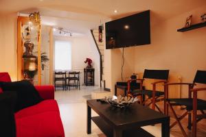 Una sala de estar con un sofá rojo y una mesa. en Rouen - La Maison Star Wars - Marvel, en Rouen