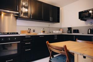 cocina con armarios negros y mesa de madera en Rouen - La Maison Star Wars - Marvel, en Rouen 54 fotos más