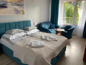 a bedroom with a bed and two chairs and a window at Altona in Władysławowo