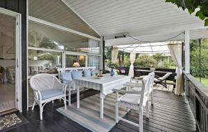 a patio with a white table and chairs on a deck at Four-Bedroom Holiday Home In Hornbak in Hornbæk