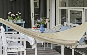 a hammock on a porch with chairs and flowers at Four-Bedroom Holiday Home In Hornbak in Hornbæk +16 photos