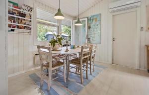 a dining room with a wooden table and chairs at Four-Bedroom Holiday Home In Hornbak in Hornbæk